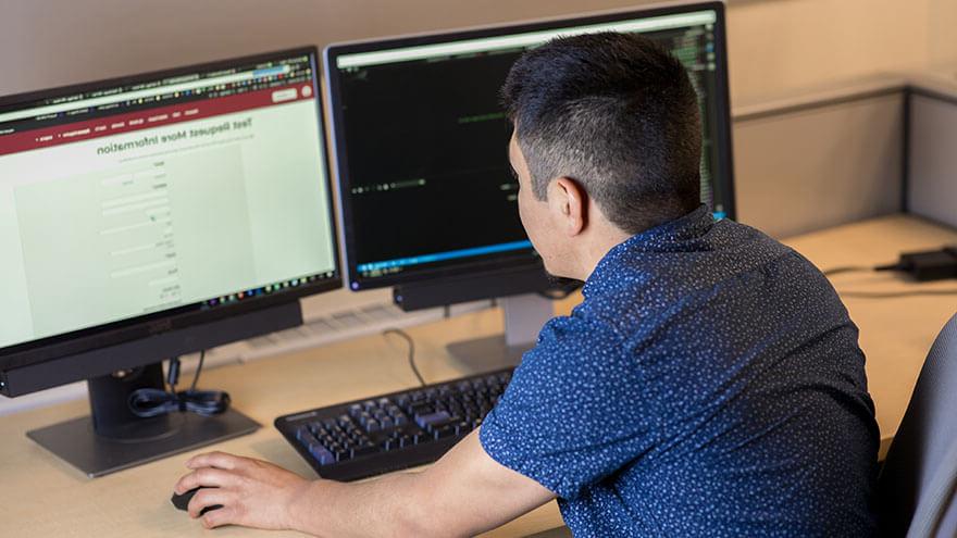 An SPU student sits at a computer, working